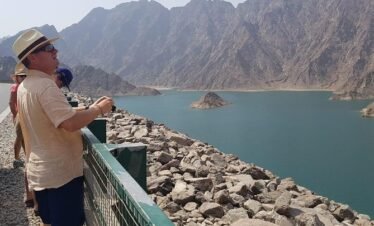 Scenic view of Hatta Dam with kayaks on turquoise water surrounded by rugged mountains